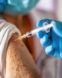 © LazysAI - Close-up shot of a healthcare professional administering a vaccine injection to a patient's upper arm, highlighting vaccination efforts.