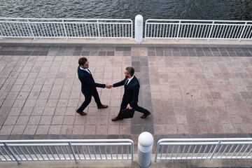 Wall Mural - The businessmen shake hands on meeting was successful and agreed. Handshake of business man. Businessmen meeting outdoor. Business team handshake. Men, shaking hands and partnership.