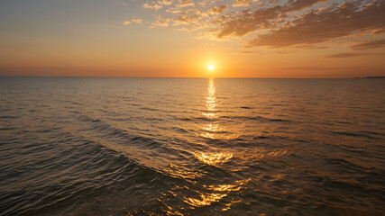 Golden sunset over a calm sea, clear weather, warm glow on the horizon
