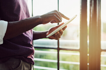 Wall Mural - Business person, hands and browsing with tablet for social media, news or connectivity by window at office. Closeup of employee scrolling on technology for online research, web or app at workplace