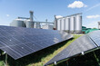© Westend61 - Solar panels on farm near metal silos at sunny day