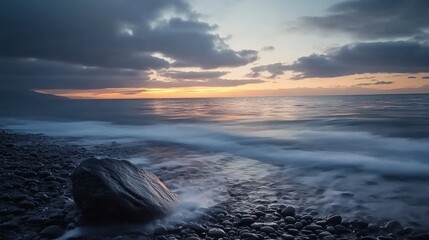 Wall Mural - A serene seascape unfolds in the soft light of sunrise, captured with a slow shutter to blur the motion of the waves.