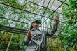 © Westend61 - Woman with VR glasses gesturing in greenhouse