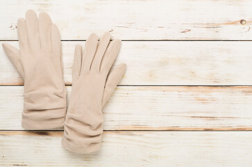 Wall Mural - Beige gloves on wooden background, top view