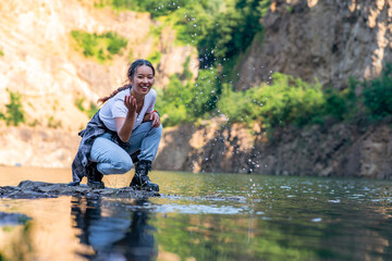 a young woman runs by the lake shore and plays with water