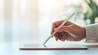 © Heng Heng - AI Stock - Closeup of a hand holding a stylus digital pen hovering over a blank digital tablet isolated against a light colored background with copy space on the left side