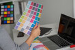 © Natee Meepian - Graphic designer reviewing color palette for creative project