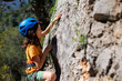 © zhukovvvlad - rock climber boy. a boy in a helmet climbs a rock. a child is rock climbing at a summer camp. rock climbing..