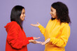 © ViDi Studio - Side profile view two fun young little kid teen girls women they wear red yellow hoodie casual clothes talk to each other chit chat isolated on plain pastel light purple background. Lifestyle concept.
