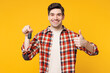 © ViDi Studio - Young smiling happy cool man he wearing red checkered shirt casual clothes hold car key fob keyless system show thumb up isolated on plain yellow orange background studio portrait. Lifestyle concept.