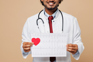 Wall Mural - Young doctor man wears white gown suit work in hospital clinic office hold electrocardiogram record heart ekg cardiogram chart of wave in paper isolated on plain beige background. Healthcare concept.