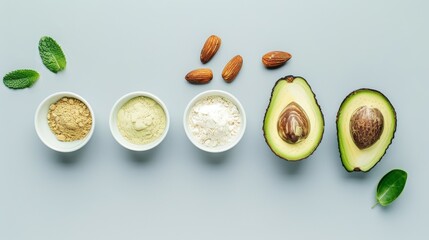 Wall Mural - A top-down view of avocados, almonds, oils, powders, and herbs on a neat green background, showcasing a variety of culinary ingredients.