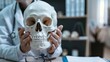 © VK Studio - A doctor holds a skull model in their hands, symbolizing the intricate relationship between medical education and human anatomy.