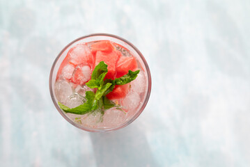 Homemade summer watermelon lemonade with ice and mint on light background, place for text