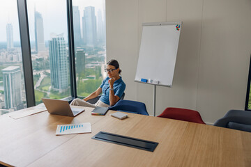 A business professional engaged in a call in a contemporary office environment with cityscape views.