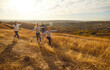 © Studio Romantic - Happy family running and having fun in the field enjoying sunset in nature. Mother, father and their children raising arms to the sides like flying and playing plane outdoors together.