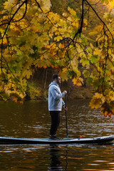 Wall Mural - Man Paddleboarding in Autumn Lake