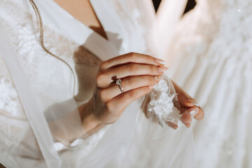 Wall Mural - A woman is holding a ring in her hand. The woman is wearing a white dress