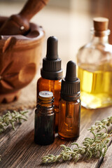 Poster - Several bottles of aromatherapy essential oil with fresh santolina plant