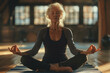 © olenap - Senior woman meditating in studio apartment, breathing positive energy. Elderly female with gray hair sitting in asana doing yoga, mindful practice. Sport for age people and healthy lifestyle concept