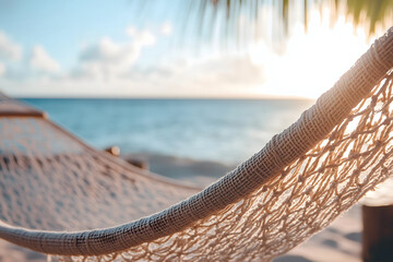 Close-up of hammock net against blurred tropical beach and ocean at sunset, copy space