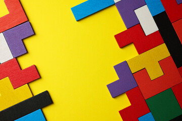 Poster - Colorful wooden puzzle pieces on yellow background, top view