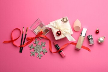 Wall Mural - Flat lay composition with makeup products and Christmas decor on pink background