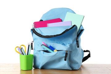 Wall Mural - Backpack with different school stationery on wooden table against white background