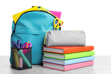 Wall Mural - Backpack with different school stationery on light grey table against white background