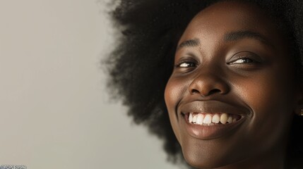 Wall Mural - Cheerful young woman with afro hairstyle smiling against a grey backdrop