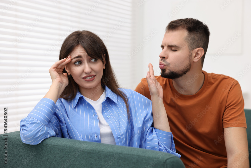 Embarrassed woman refusing from man's kiss at home Stock Photo | Adobe ...