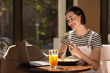 Canvas Print - Happy woman having tasty breakfast in cafe