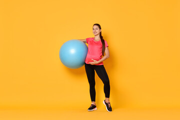 Canvas Print - Beautiful pregnant woman with fitball on yellow background