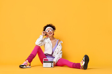 Wall Mural - Aerobics. Woman with radio receiver on orange background