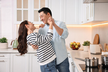 Poster - Happy lovely couple dancing together in kitchen