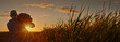 © StockMediaSeller - Wide shot: Silhouette of a farmer walking along a dirt road at sunset, carrying a sack of potatoes with cornfields in the background.