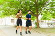 © AntonioDiaz - Full length view of a man and a woman joggging together in a city park with trees, enjoying their daily exercise