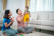 © SKW - A man and a woman are holding a baby. The baby is wearing yellow shorts. The man is holding a toy in his hand. Scene is happy and loving