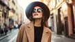 © Phatharaporn - Stylish Woman in a Brown Coat and Hat in the City.