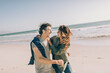 © Marko Geber - Happy couple walking and laughing together on a sunny beach