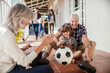 © Marko Geber - Multigenerational family playing soccer on house porch