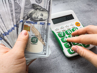 Poster - woman counting us dollar money cash with calculator on desk