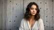 © Vitalii - Pretty brunette young woman on the background of a concrete wall. Generative AI