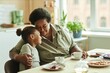 © Seventyfour - Medium shot of doting grandma gently embracing little granddaughter with love and affection while having tea sitting at table against window at sunlit kitchen, copy space
