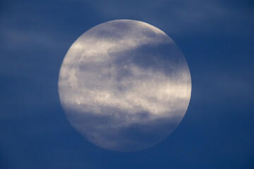 Wall Mural - photograph of the full moon partially covered with clouds