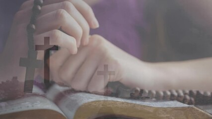 Wall Mural - Praying hands holding rosary beads over open Bible with cross animation