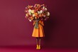 © netrun78 - A woman stands gracefully, wearing an orange dress and yellow shoes, while balancing a large bouquet of colorful autumn flowers on her head, framed by a bold burgundy background.