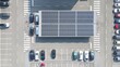 © TechAnimationStock - Aerial top down photovoltaic solar panel EV charging station in a parking lots with modern electric car recharging their lithium-ion batteries