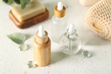 Wall Mural - Cosmetic dropper bottles with soap and sponge on light background, closeup