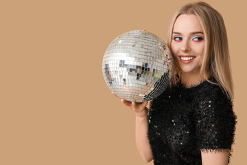 Wall Mural - Beautiful young woman with disco ball on brown background